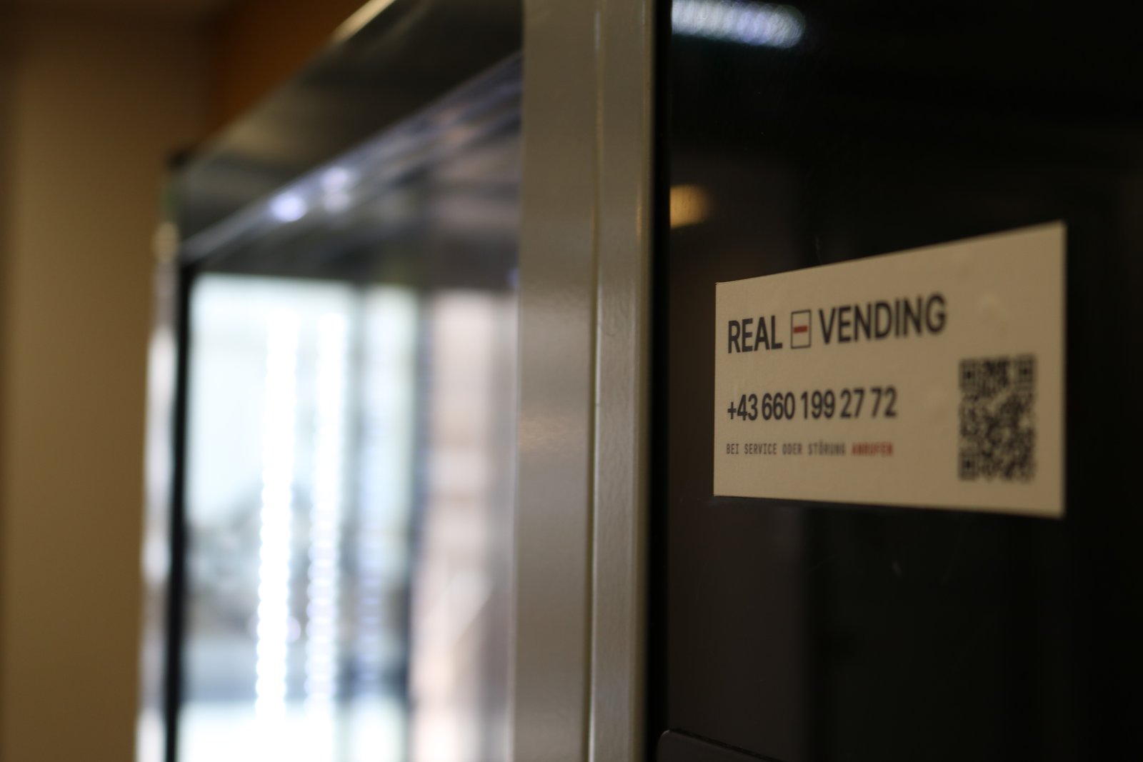 Real-Vending-Automat am Standort mit Kontakt-Aufkleber und QR-Code